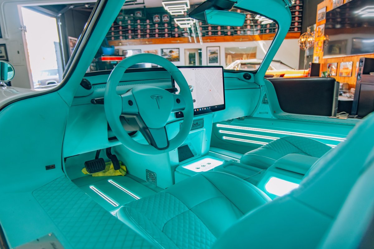 The interior, in Tiffany colours, replete with Tesla steering wheel and central screen.